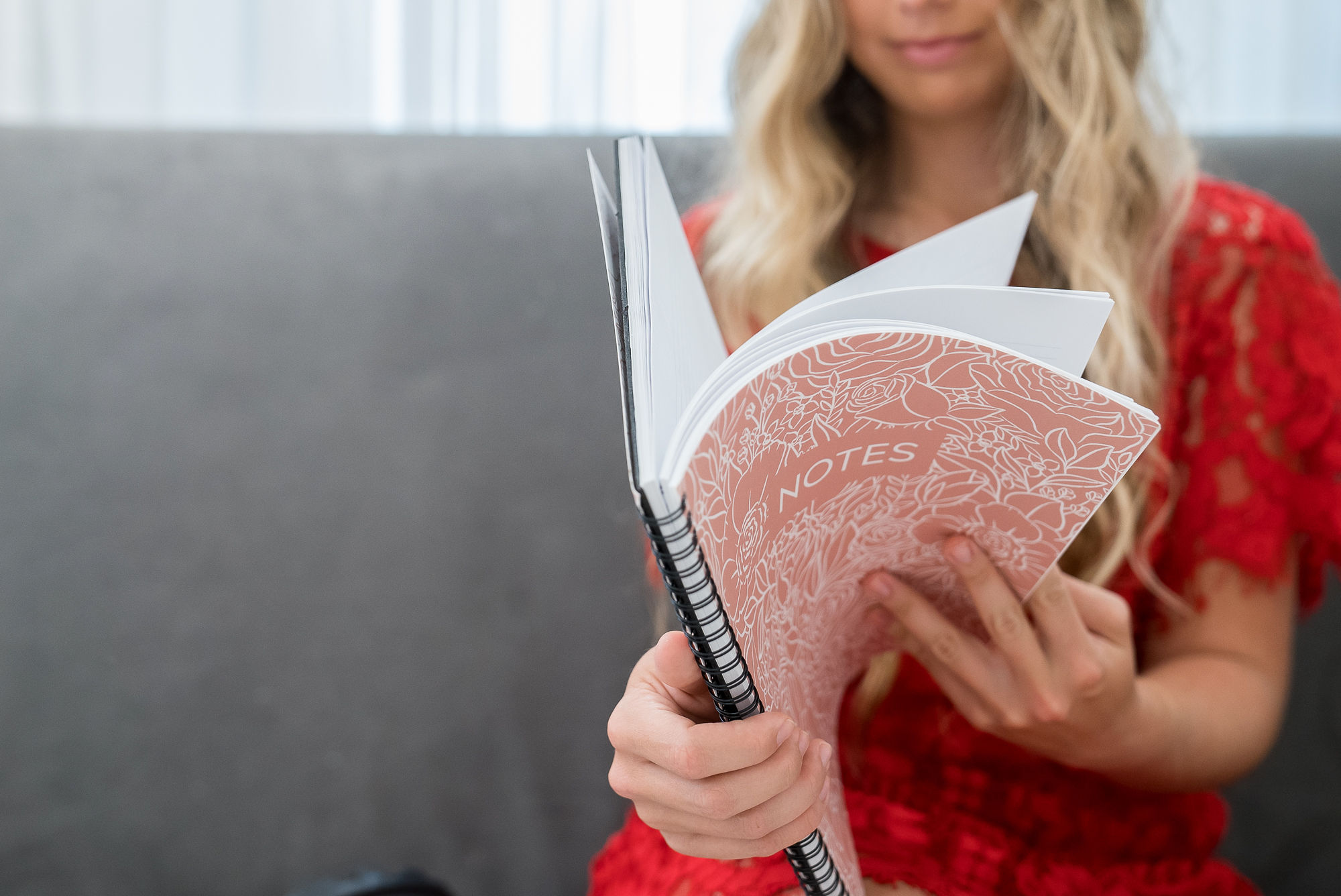 girl in red dress flipping through notebook